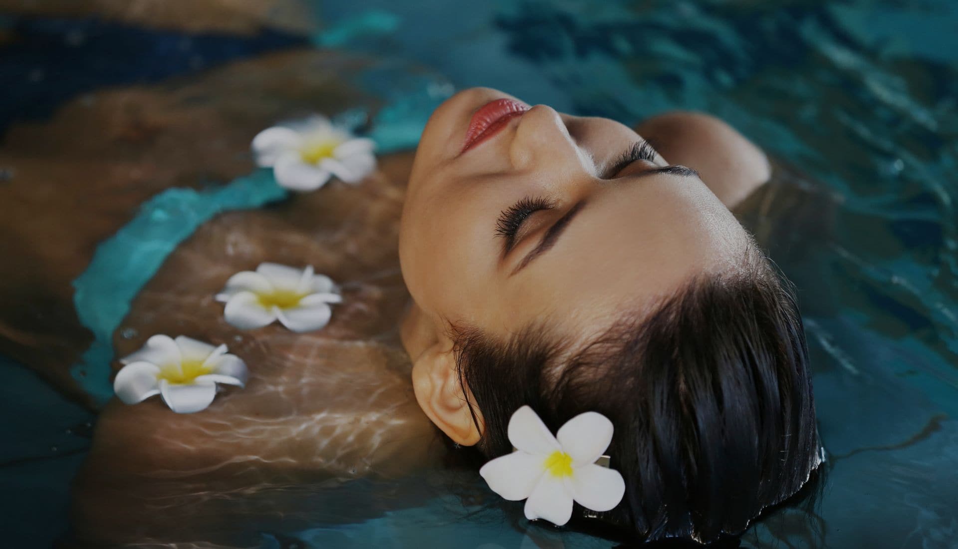 woman in a pool with flowers floating