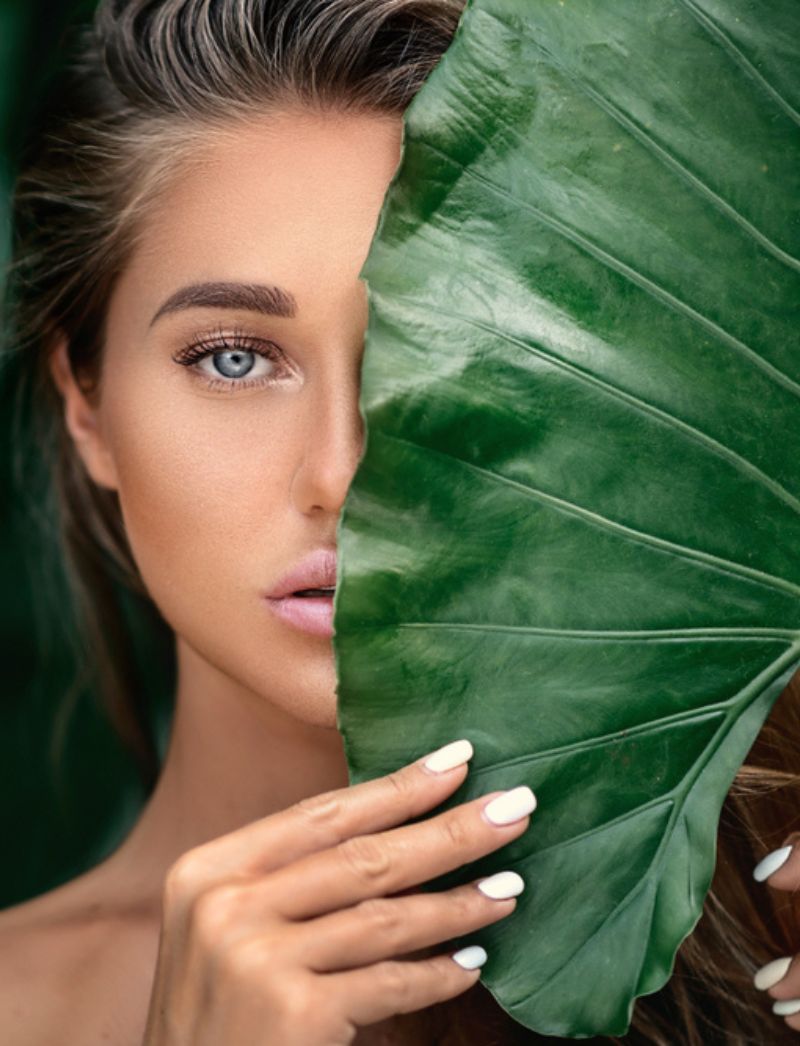 woman holding tropical leaf