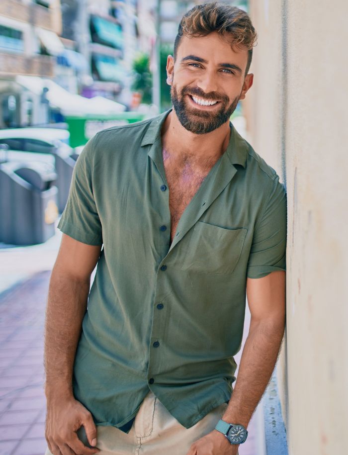 handsome man leaning against a wall