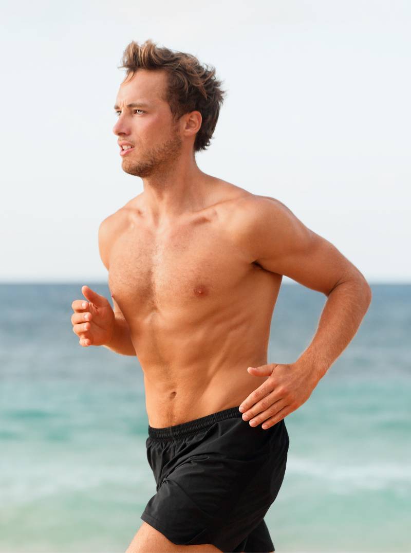 healthy fit man running at the beach